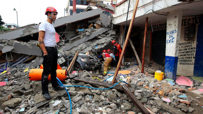 Equipos de rescate trabajan junto a un local comercial derrumbado, con la losa del piso superior caída sobre la vereda
