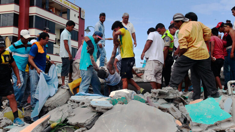 Grupo de vecinos y socorristas retira a una persona de entre las losas de una construcción colapsada
