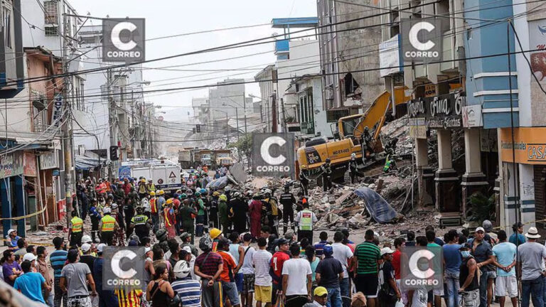 Multitud observa las labores de remoción de escombros con maquinaria pesada en una calle comercial del centro de la ciudad