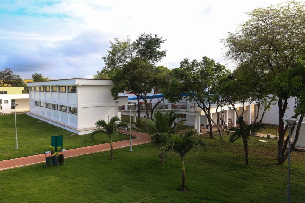 Bloque de aulas del colegio Olmedo de Portoviejo terminado, con jardines, palmeras y corredor cubierto
