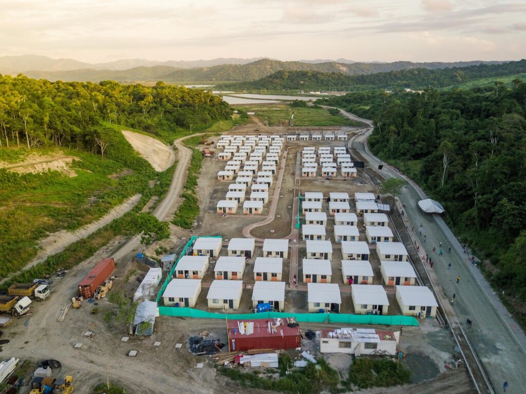 Vista aérea del conjunto de viviendas unifamiliares de El Matal en un valle, con casas entregadas y frente de obra aún activo